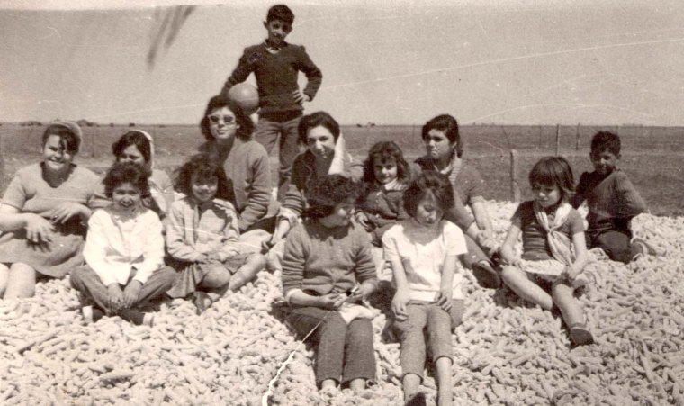 María Teresa Andruetto, la niña del pañuelo en el cuello, en un picnic el día del estudiante, con sus compañeros de piano, en un campo de la llanura cordobesa. Están sentados sobre una montaña de marlos (mazorca de maíz ya desgranado). La que se toca la cabeza es la maestra.